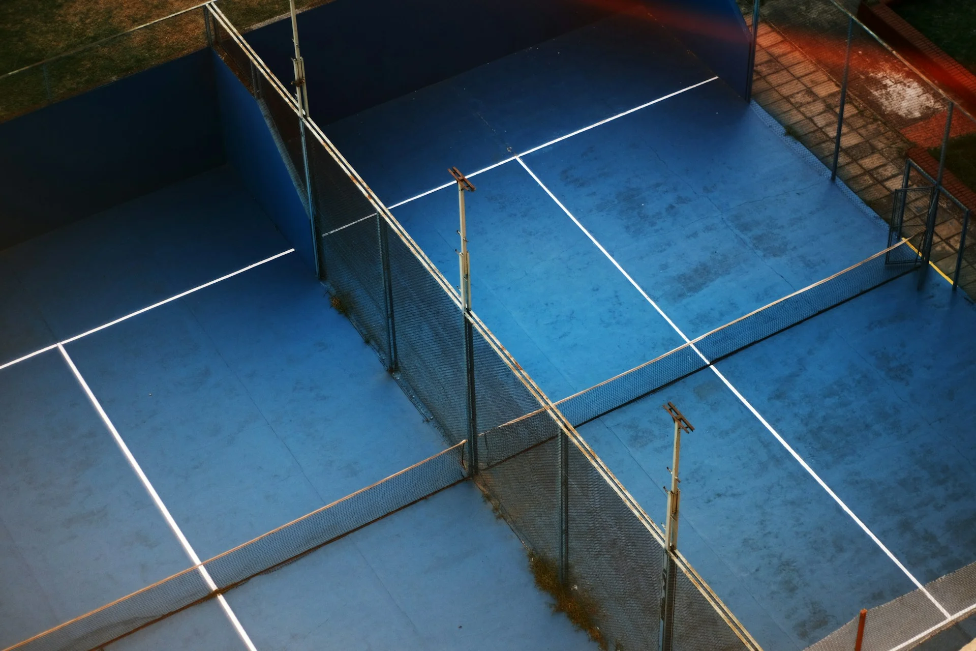 Vista de um campo de padel com superfície artificial azul